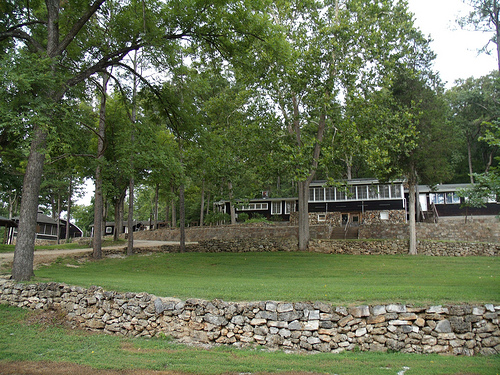 a rock retaining wall with building in the background