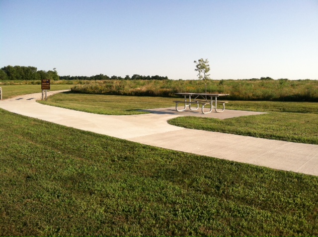 picnic table sitting along side a concrete pathway