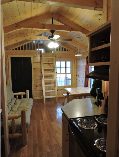 Interior of cabin showing stove, futon, table and loft