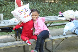 a girl shows off the scarecrow she made at an event