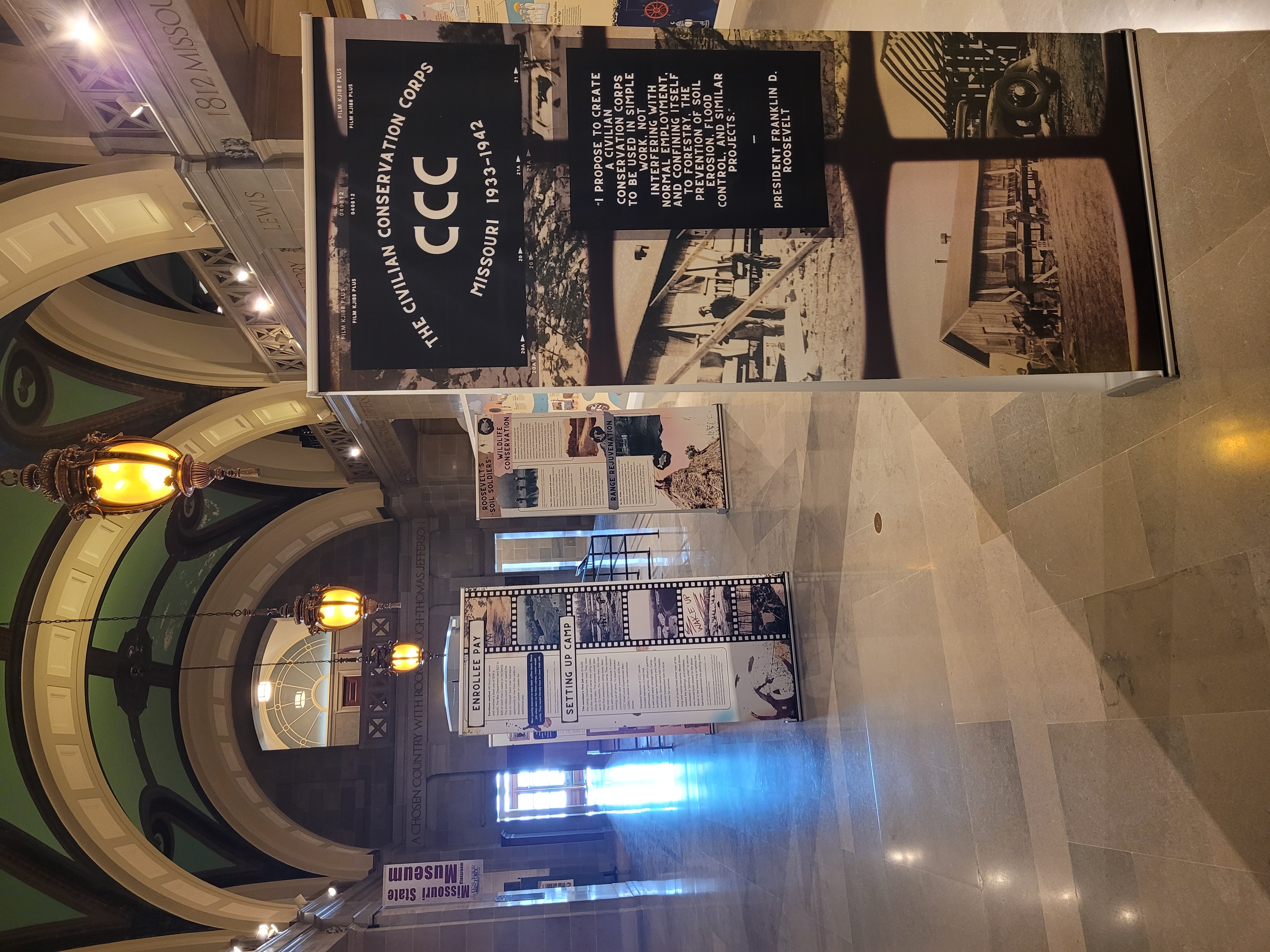 CCC display board in large hallway with other display boards behind it
