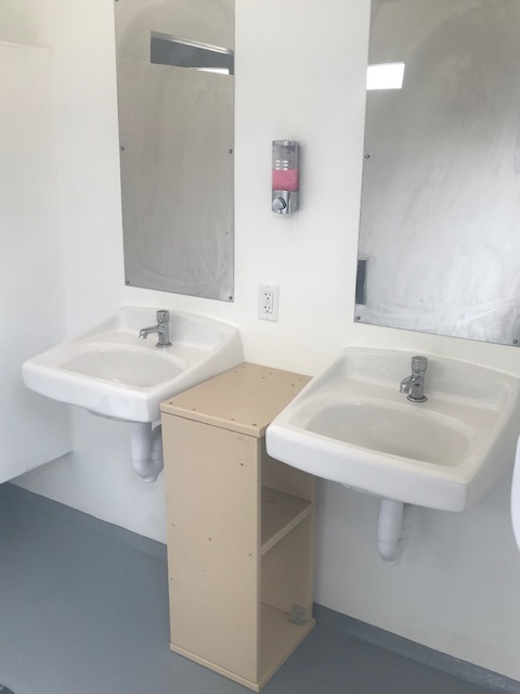 Two sinks, soap dispenser and outlet inside showerhouse