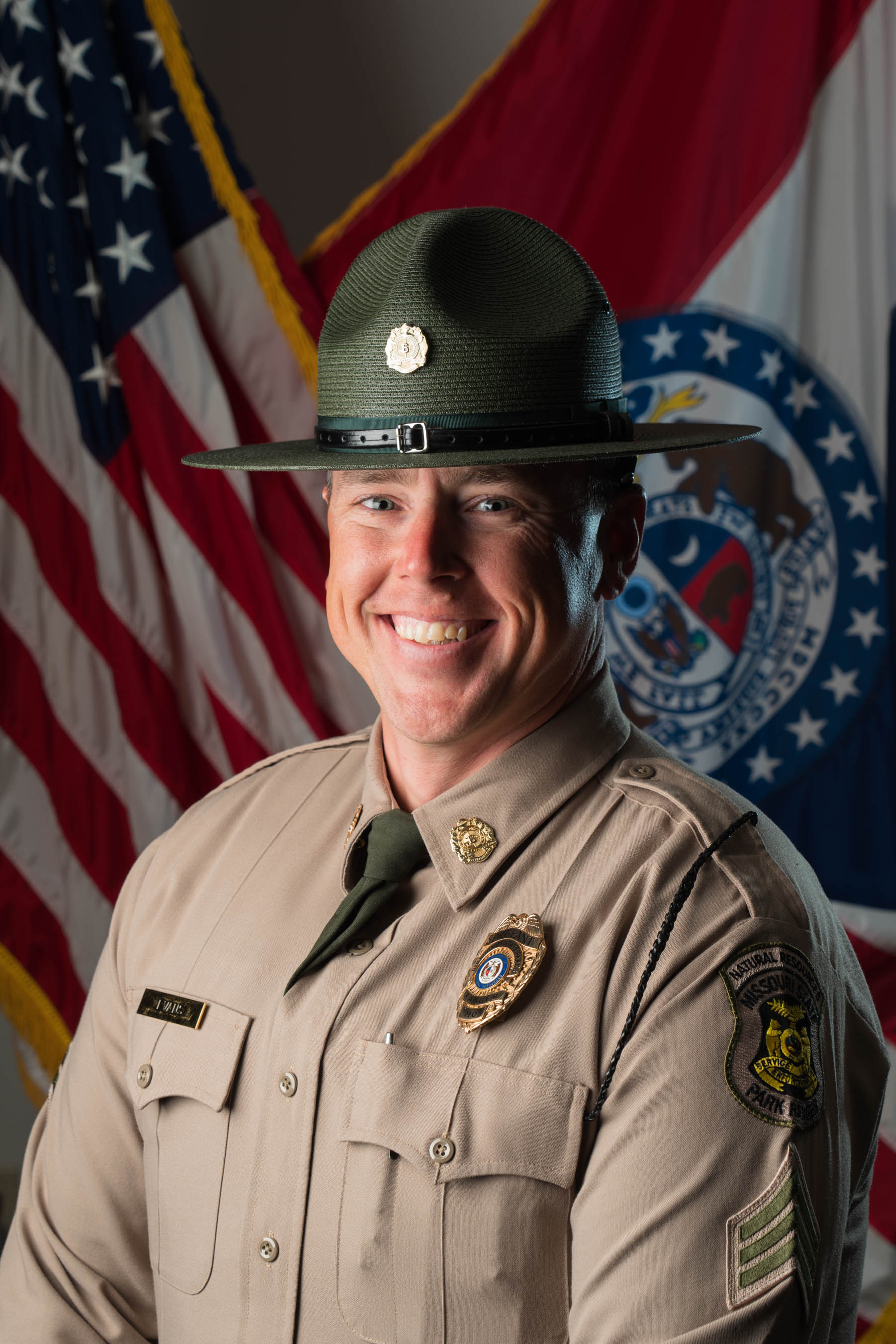 Geoffrey Evans in hat and uniform with U.S. and Missouri flags and background