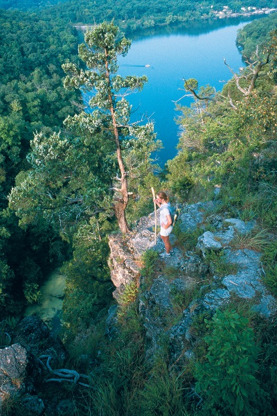 a hiker enjoying a view of the Lake of the Ozarks from a bluff at Ha Ha Tonka State Park
