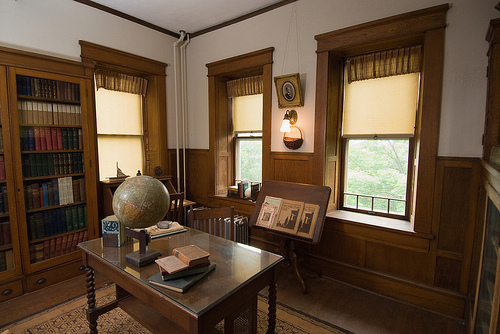 a desk and books shelves filled with books in the home's library