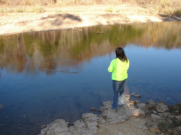 girl fishing on the bank of the river