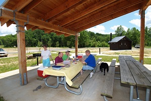 people enjoying a picnic lunch under one of the shelters