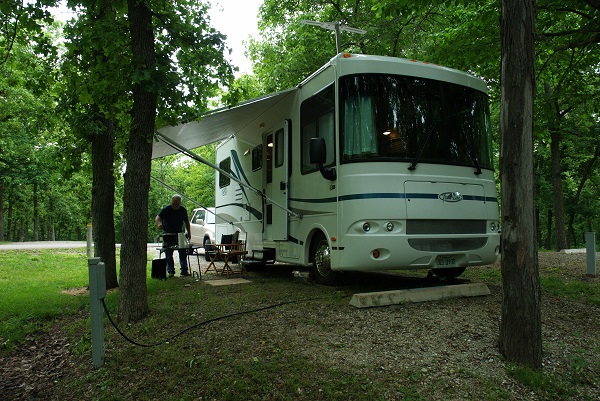 an RV parked on a campsite under trees