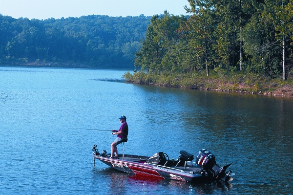 A man fishing out of his boat on a lake