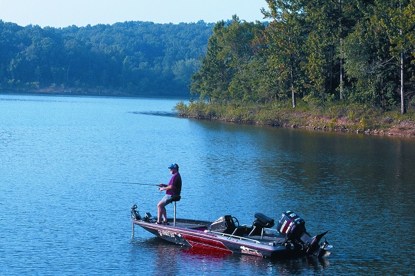 man fishing from a boat on the lake