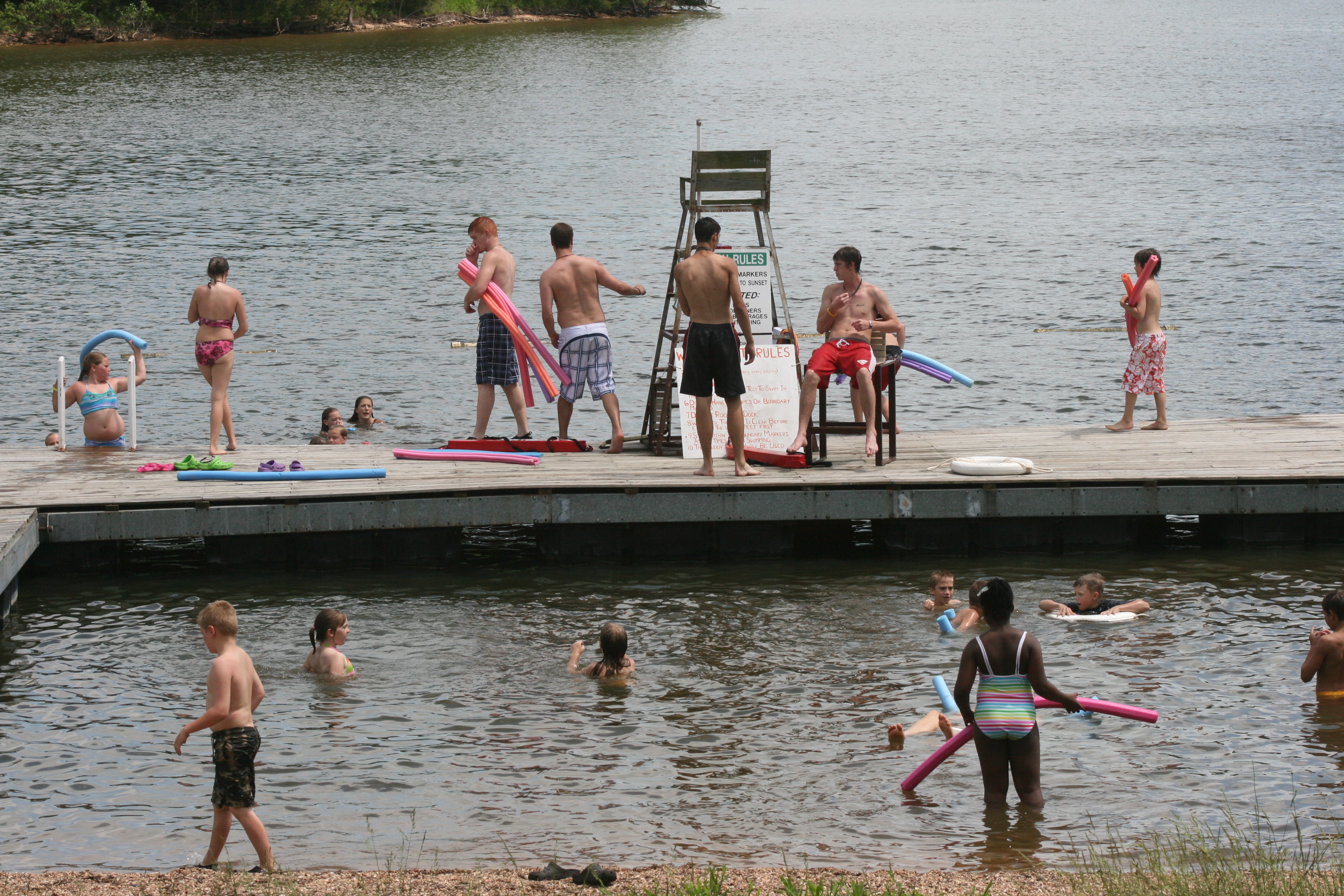 Kids on the swimming dock and swimming in the lake