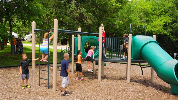 kids playing on the playground equipment with monkey bars and slides