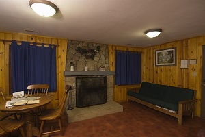 fireplace, dining table and futon inside a cabin