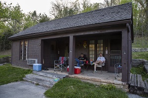 a man sitting on the porch of a cabin