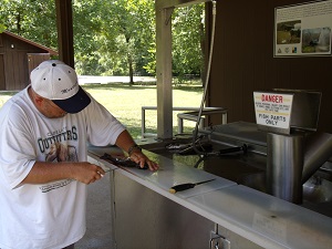 man cleans a fish at the fish cleaning station