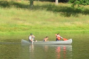 three people in a canoe on the lake