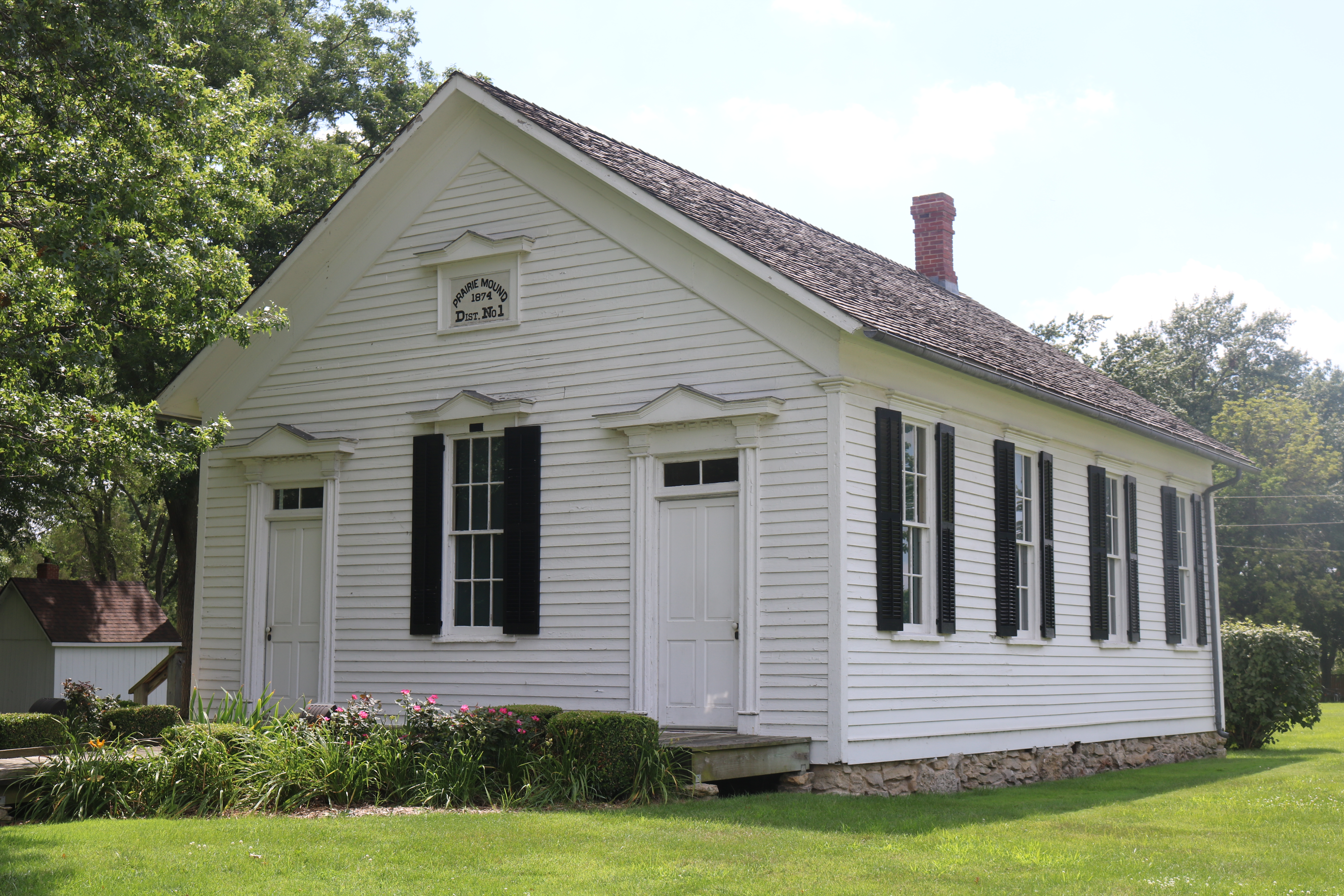 Exterior of little white school building