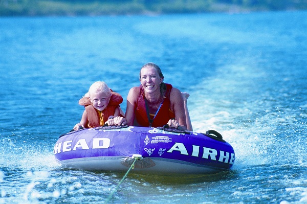 A mother and young daugher tubing on a lake