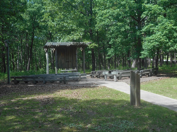 sidewalk leads to wooden benches and stage of amphitheater 