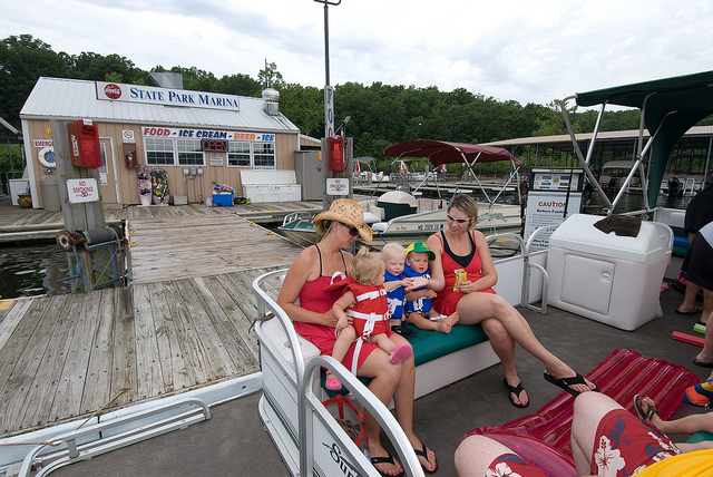 people sitting in a pontoon boat by the marina dock