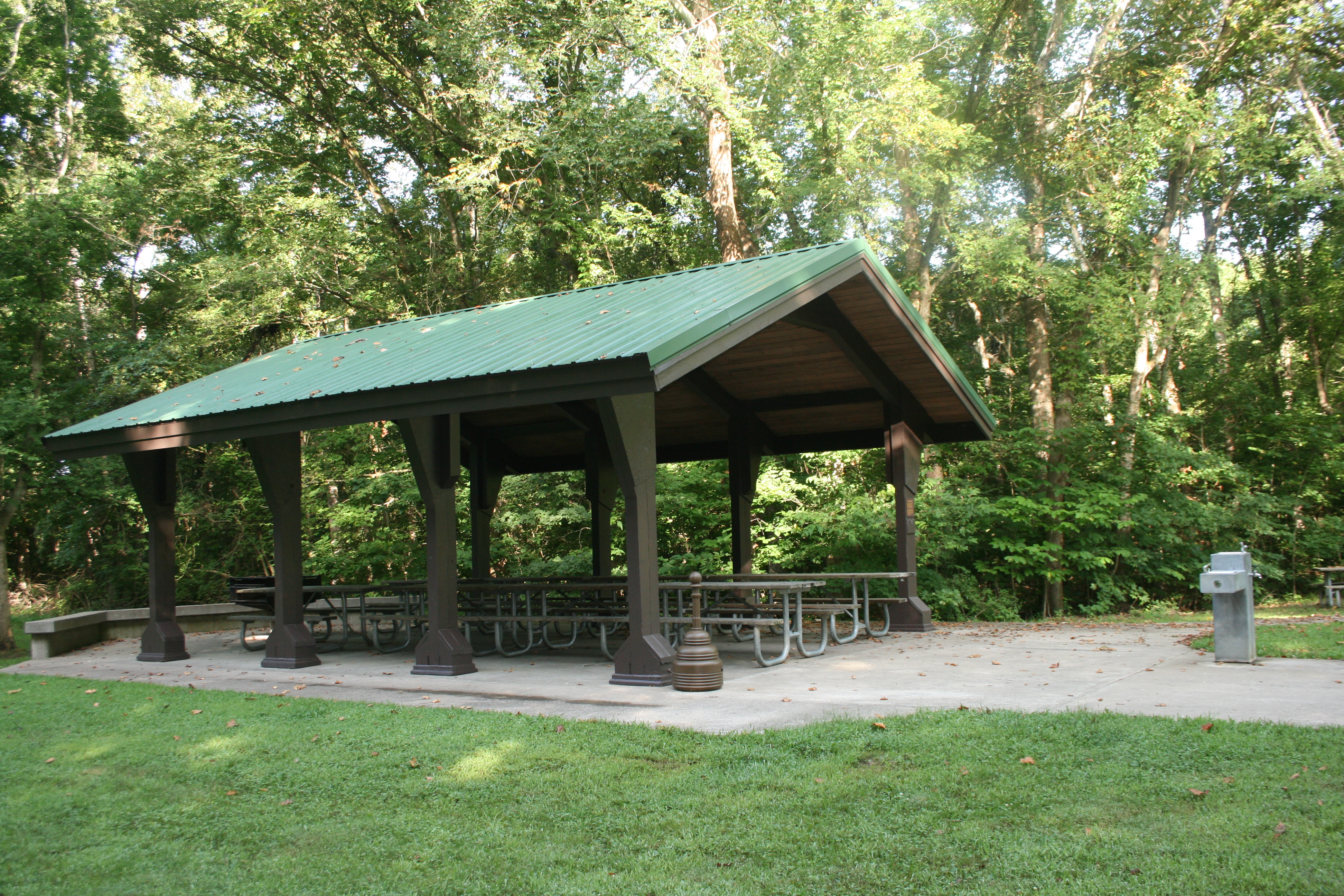 Side and front view of open pavilion-style shelter and nearby water fountain