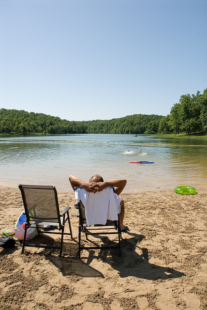 a person relaxing in a lawn chair on the beach