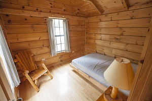 bed and chair inside camper cabin