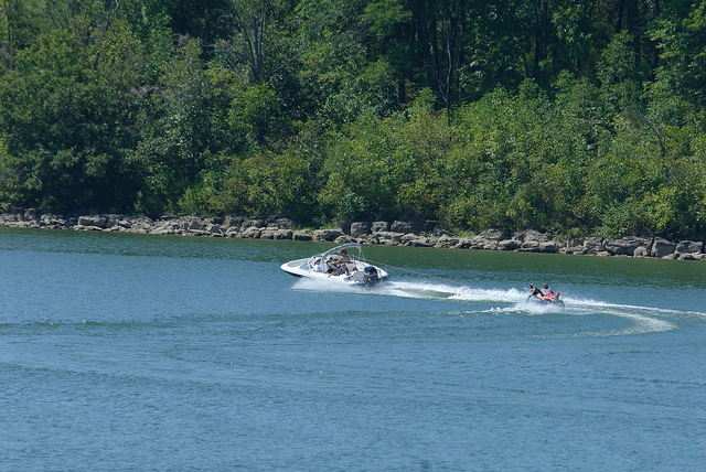 a boat pulling a person on a tube