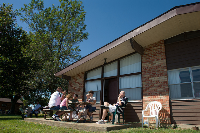 a family sits at the picnic table outside of their duplex cabin