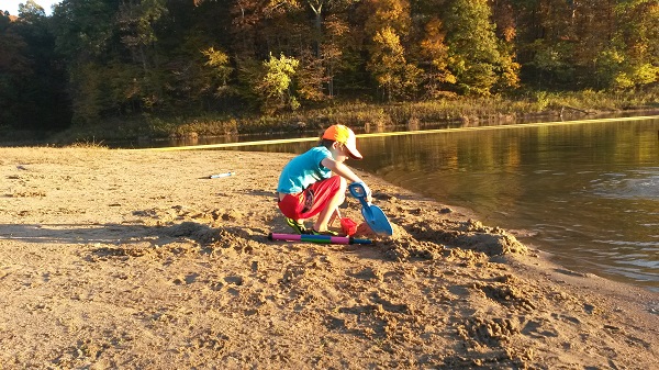 a kid playing in the sand on the beach