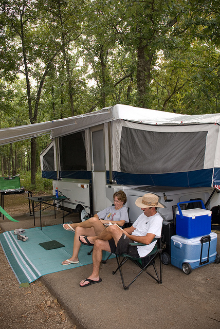 two people sitting oustide their camper reading