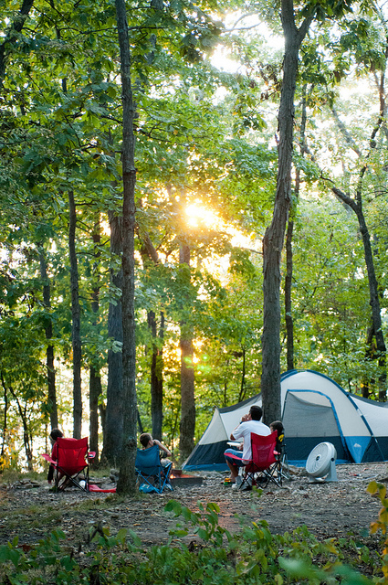 people sitting in lawn chairs outside of their tent