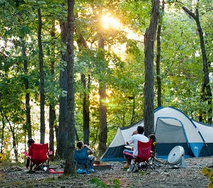 people sitting in lawn chairs outside their tent