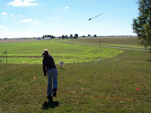 a girl tosses an atlatl