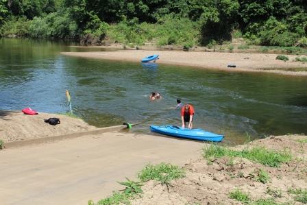 a person launches a kayak from the boat ramp