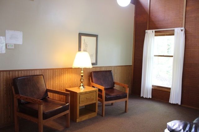 two chairs with a lamp on table between them