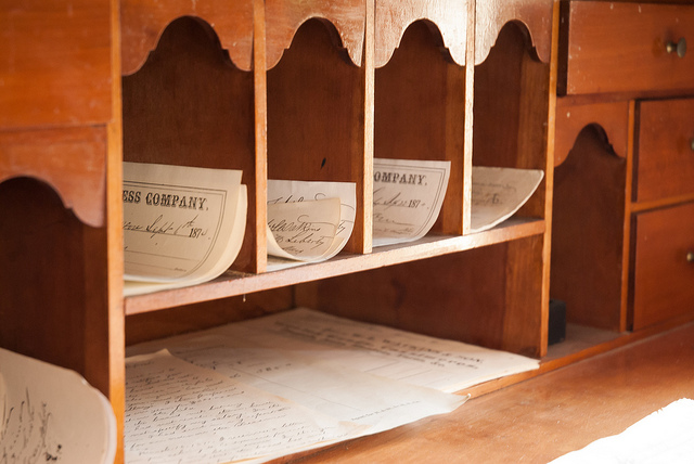 papers sorted in a wooden mail bin