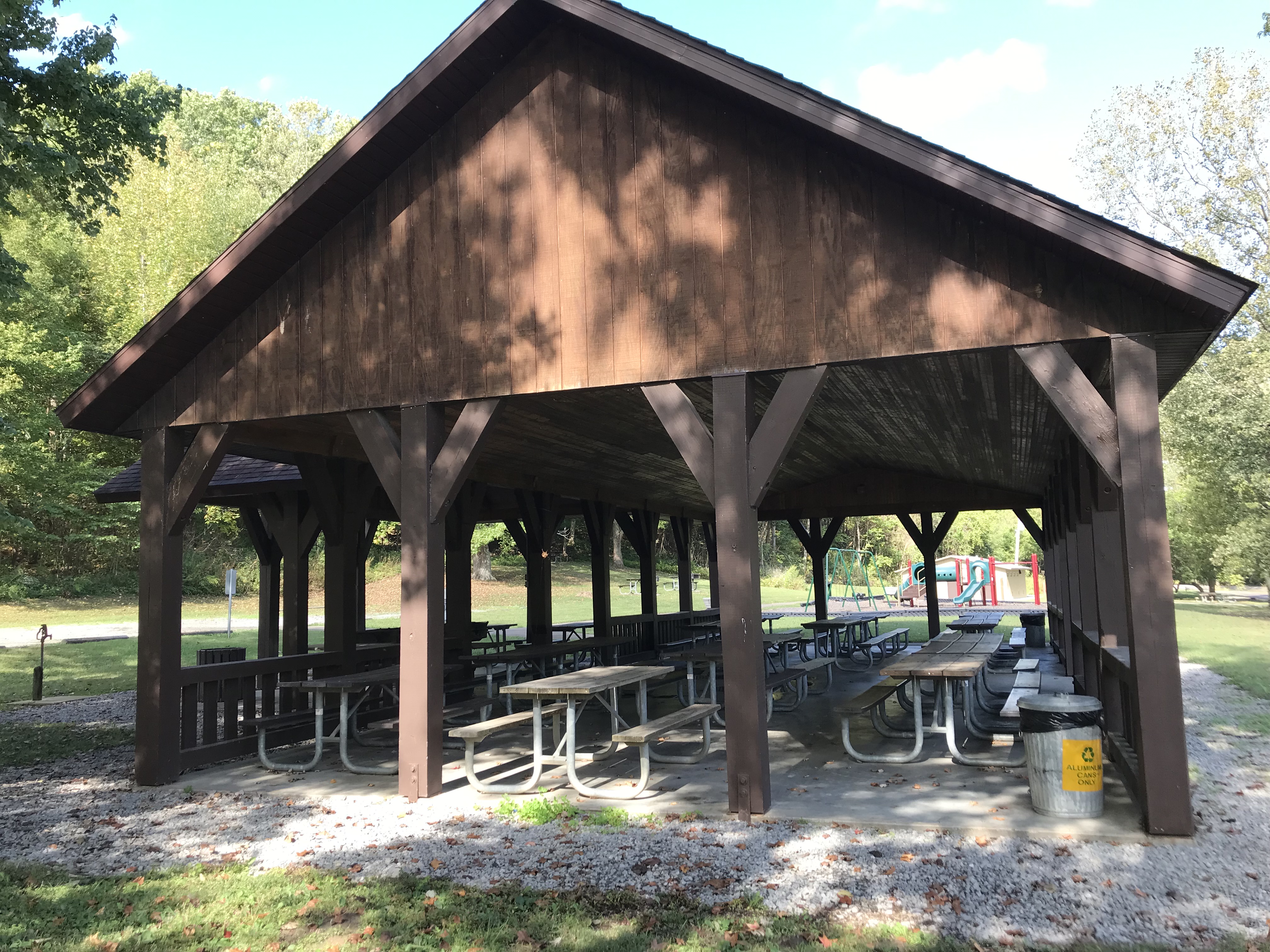 Large wooden shelter with playground in background