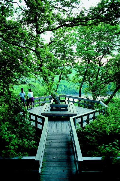 two people standing on the octagon-shaped wooden overlook with a view of the Missouri River