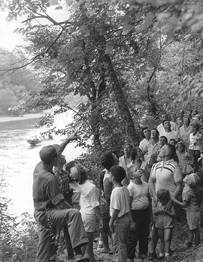 historic photo of naturalist leading a group on a hike