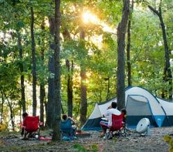 people sitting in lawn chairs outside their tent