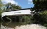 A white covered bridge over a river