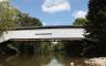 A white covered bridge over a river