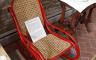 A wicker chair with a red metal frame
