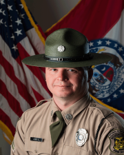Ranger Chris Crider standing in-front of flag