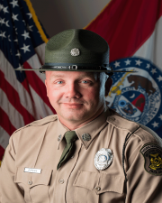 Ranger Jason Gordon standing in-front of flag
