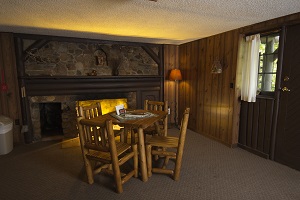 cabin interior with table, chairs and fireplace