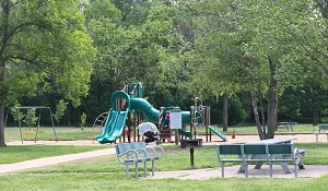 benches near playground equipment with slides and a swing