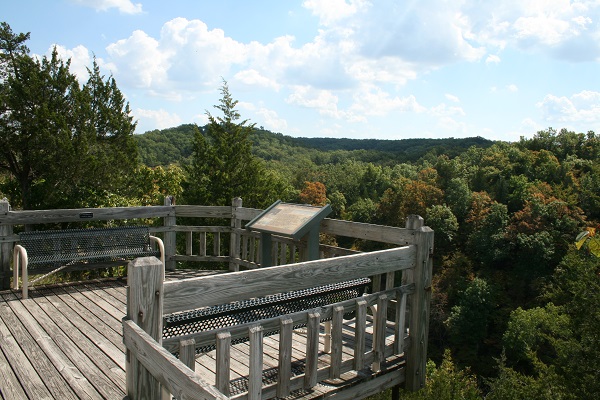 wooden overlook deck overlooking tree-topped hills