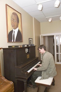 guy playing the piano inside the Joplin house